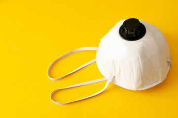 Protective face mask on yellow background. Copy space. Quarantine easter concept. Antibacterial.