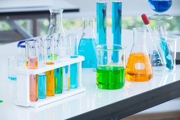 Preparing Laboratory equipments such as glassware, tube with liquid on the white table. The chemistry experiment in scientific research