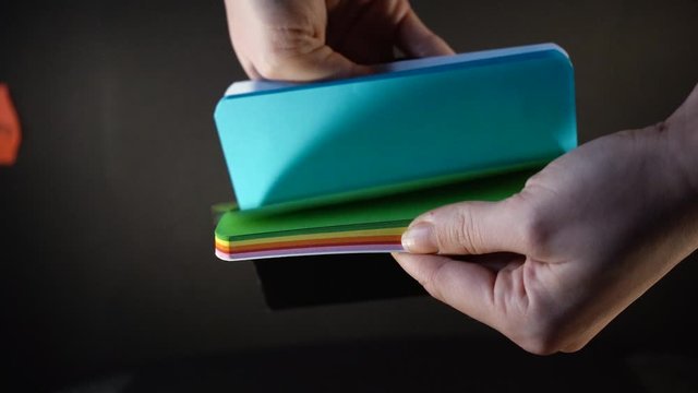 Woman's hand looking at colored notebook . Shot from above with the Sony a7iii.