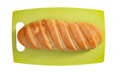 Isolated loaf of bread on green cutting board on white background.