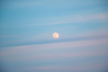 full moon in evening sky with clouds