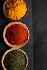 Various spices on a black background, top view, with copy space. Condiments of cooking concept.