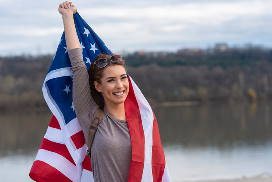 Pretty young woman holding american flag