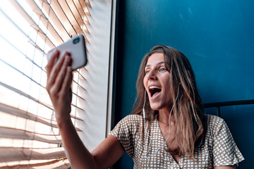 A beautiful young female surprised during a videocall at time. Due to Coronavirus (Covid 19) people...