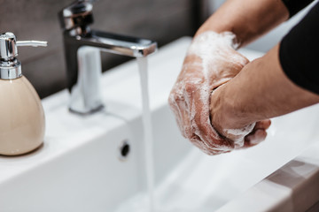 Coronavirus pandemic prevention wash hands with soap warm water and , rubbing nails and fingers washing frequently or using hand sanitizer gel.