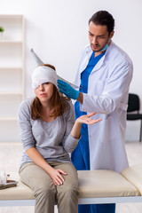 Young head injured woman visiting young male doctor