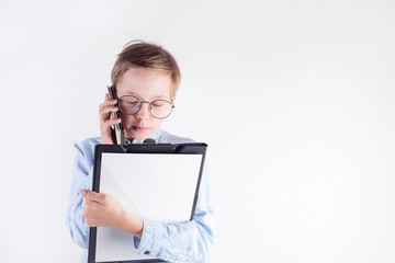 Young boy in glasses and mockup paper clipboard in his hand is on the phone against light grey background.