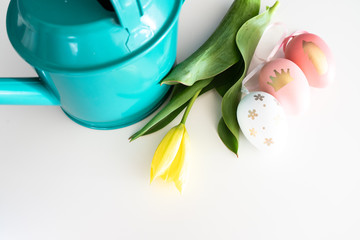 tulip arranged with colored eggs and turquoise watering can - easter mockup - overhead view