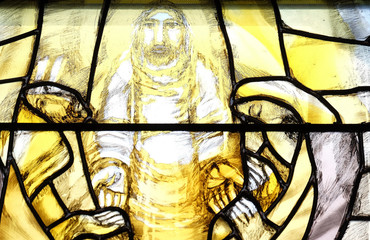 God begins salvation in this world through His Son Jesus Christ, detail of stained glass window by Sieger Koder in St. John church in Piflas, Germany
