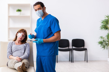 Fototapeta premium Young head injured woman visiting young male doctor