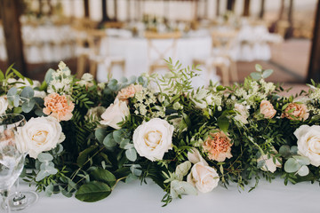 banquet table decorated with compositions of flowers and greenery