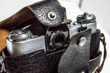Retro camera with old leather case. Vintage, retro, closeup. Selective focus, film grain effect.