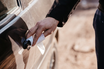 Cleansing car interior and spraying with disinfection liquid. Hands in rubber protective glove disinfecting vihicle inside for protection from virus corona disease