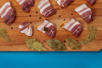 On a Board made of wood for cutting is meat for snacks, spices for meat, Bay leaf, black pepper