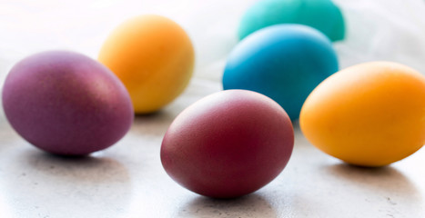 Colorful easter eggs on grey concrete table. Front view. Selektive focus. Easter decoration. 