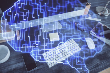 Double exposure of table with computer and brain hologram. Data innovation concept.