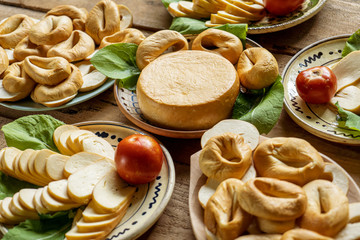 Local food in Romania. Asorted organic milk hard cheese on traditional handmade plates