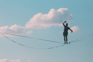 Highliner on the background of blue sky.