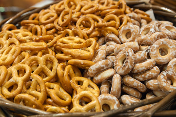 Salty pretzels close-up in wicker basket, top view. Oktoberfest mini pretzel, beer snack.