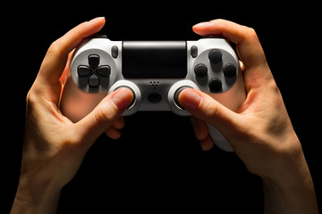 Hyman hands holding white video game gamepad isolated on a black background