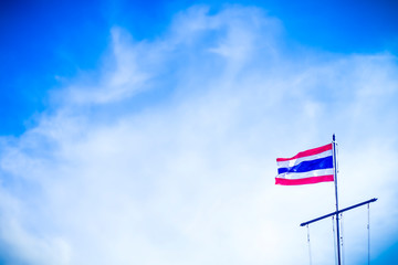 Naklejka premium National Thailand flag hang on top pole over clear blue sky background. Symbol of Thailand blow in wind.