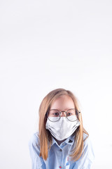 Beautiful young girl in a medical protective mask against light grey background.