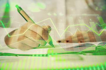 Multi exposure of woman's hands making notes with forex graph hologram. Concept stock market analysis.