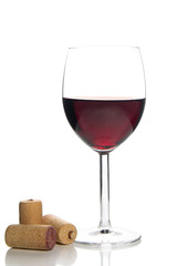 red wine glass and corks on white background