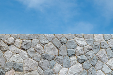 Stone wall background  texture under blue sky on sunshine day.