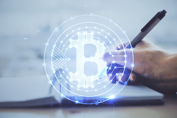 Cryptocurrency hologram over hands taking notes background. Concept of blockchain. Multi exposure