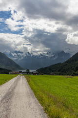 The road leading a mysterious gorge surrounded by clouds of the Norwegian mountains, selective focus