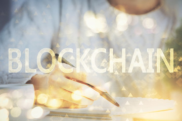 Cryptocurrency hologram over hands taking notes background. Concept of blockchain. Multi exposure