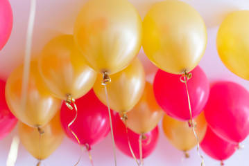 red and gold balloons with helium under the ceiling for a birthday party