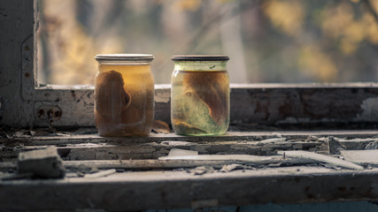 Glass jars with liquid standing at window of abandoned school in Pripyat near Chernobyl in Ukraine