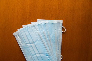 Close up medical face mask on wooden table background, Selective focus to green face mask on wood background.