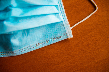 Close up medical face mask on wooden table background, Selective focus to green face mask on wood...