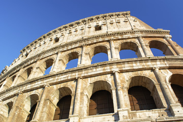 Obraz premium Part of Colosseum at blue sky in Rome, Italy, Europe.
