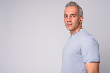 Profile view of handsome Persian man looking at camera