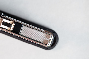 black stapler for fastening papers on a gray background
