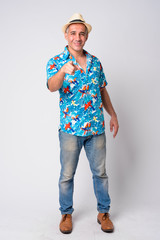 Full body shot of happy handsome Persian tourist man pointing at camera