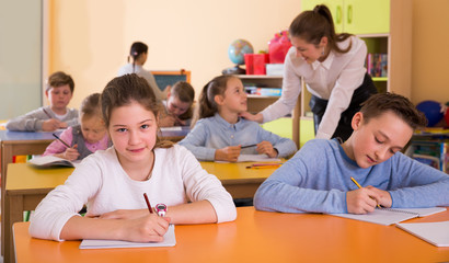 Fototapeta na wymiar Portrait of schoolgirl and children in classroom