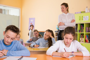 Fototapeta premium School kids studying in classroom with teacher