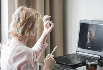 A woman talking on skype at home office