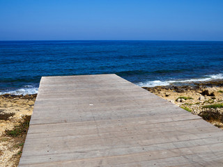 Fototapeta na wymiar Famous coastal broadwalk path surrounding the archaeological park Paphos Cyprus