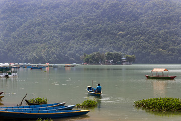 Obraz premium boaters sail a small boat without tourists on the lake. Countries empty without tourists because of the threat of coronavirus. travel agencies were left without customers, the impact to your business