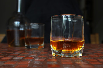 Glass of scotch whiskey on dark background