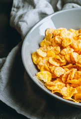 Tasty crispy corn flakes in bowl on the rustic background. Selective focus. Shallow depth of field.