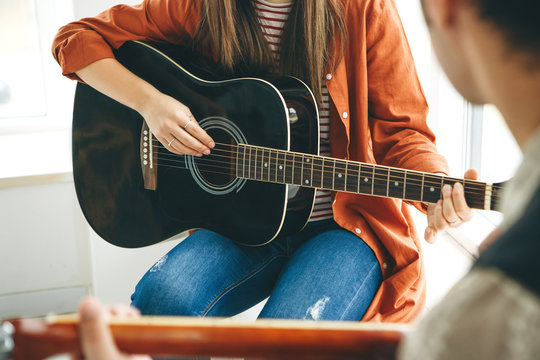 Learning to play the guitar. The teacher explains to the student the basics of playing the guitar. Individual home schooling or extracurricular lessons.