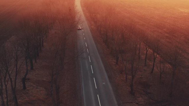 FEW SHOOTS MONTAGE. Fast red sport car goes on the road between trees on sunset, driver turn gearbox transmission, air aerial drone shoot motor rews