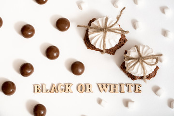 Chocolate Day July 7th.Sweets on white background, a steak of white and black chocolate. concept of choice. White marshmallows or dark bitter chocolate.The inscription on the card